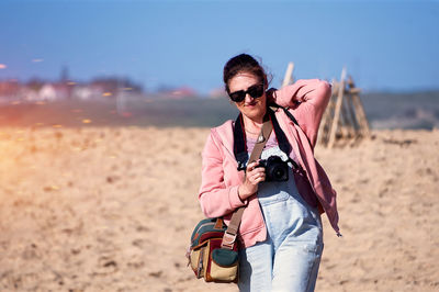 Portrait of young woman standing at beach