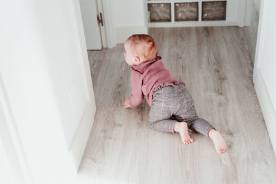 High angle view of cute baby girl crawling at home