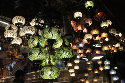 Illuminated lanterns hanging at market stall