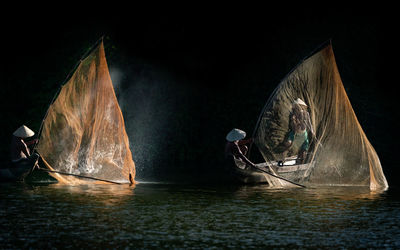 Boats sailing in sea at night