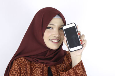 Portrait of a smiling young woman against white background