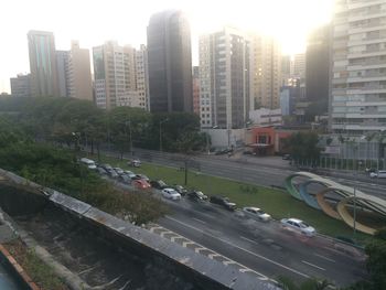 Vehicles on road against buildings in city