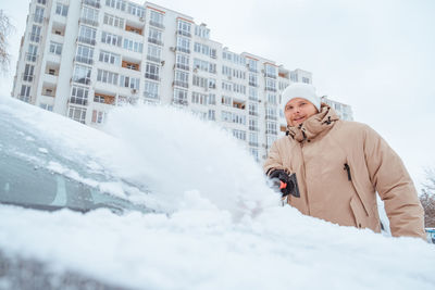 Portrait of young woman standing on snow