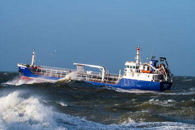 Ship sailing in sea against clear sky