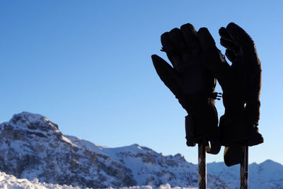 Low angle view of snowcapped mountain against clear blue sky