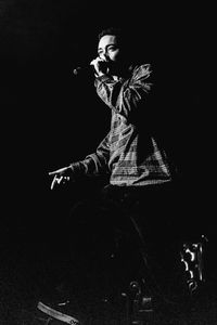 Midsection of man dancing against black background