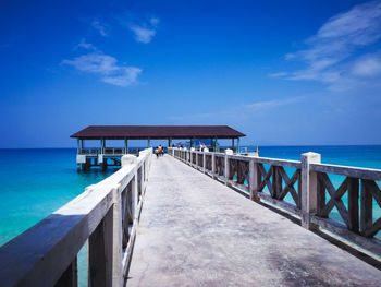 Pier over sea against blue sky