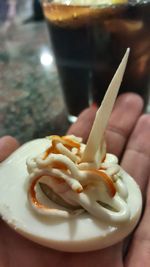 Close-up of hand holding ice cream in plate