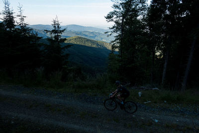 Bicycle on mountain in forest against sky