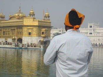 Rear view of man in temple against sky in city