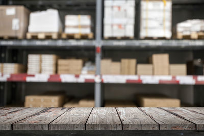 Wooden table against shelves at warehouse