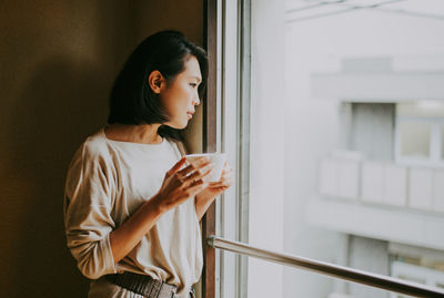 Young woman drinking coffee at home