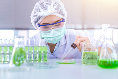 Female scientist performing experiment at table in laboratory