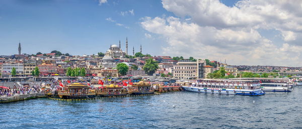 Boats in river against buildings in city