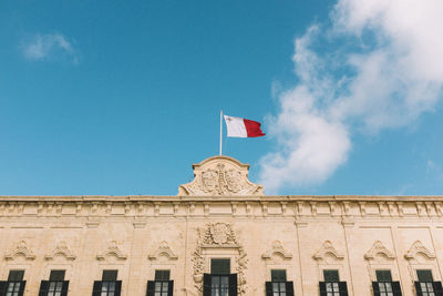 Low angle view of flag against blue sky