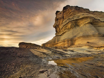 View of rock formations against cloudy sky