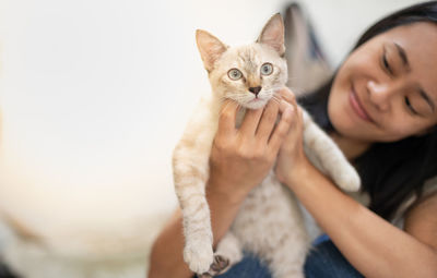 Portrait of woman holding kitten