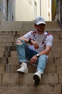 Full length of young man sitting on steps