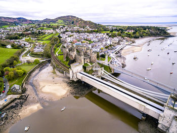 High angle view of river amidst cityscape against sky