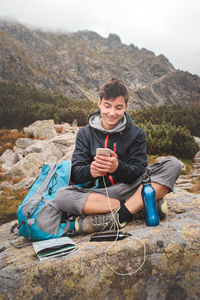 Portrait of man sitting on rock