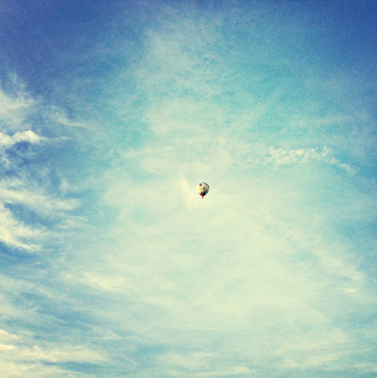 low angle view, flying, mid-air, sky, extreme sports, blue, cloud - sky, adventure, transportation, parachute, nature, freedom, leisure activity, cloud, air vehicle, paragliding, on the move, beauty in nature, outdoors