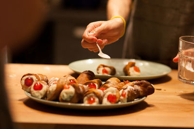 Midsection of person eating food on table