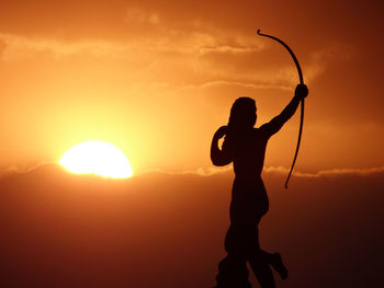 Silhouette man standing against sky during sunset