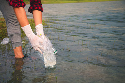 Low section of woman standing in lake