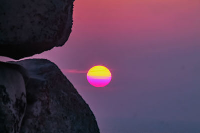 Close-up of rocks against sea during sunset