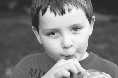 Close-up portrait of cute boy drinking juice