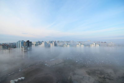 View of cityscape against sky during foggy weather