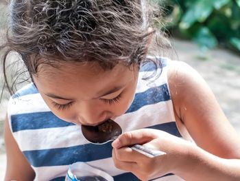 Close-up of girl eating food with spoon