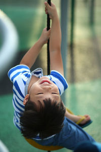 Happy boy swinging in playground