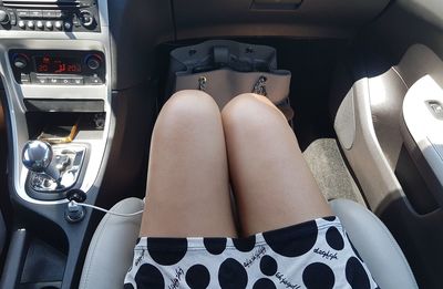 Low section of woman sitting in car