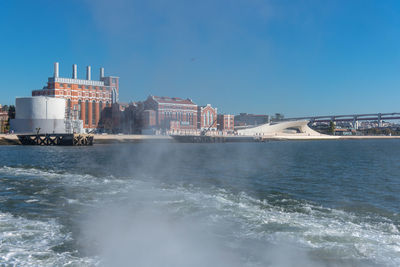 Scenic view of sea by buildings against clear sky