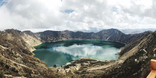 Scenic view of lake and mountains against cloudy sky