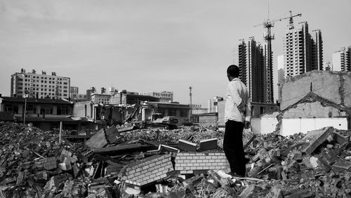 Man standing on construction site against buildings in city