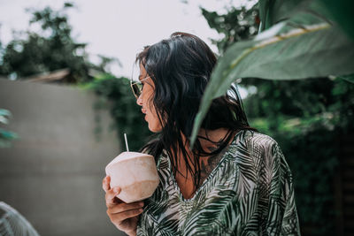 Portrait of young woman drinking water