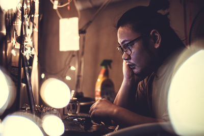 Side view of man using laptop at table