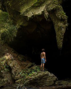 Rear view of woman standing on rock