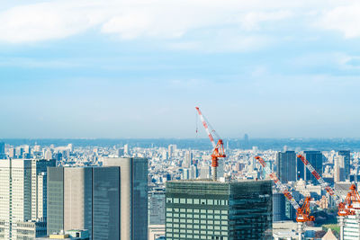 Aerial view of city by sea against sky