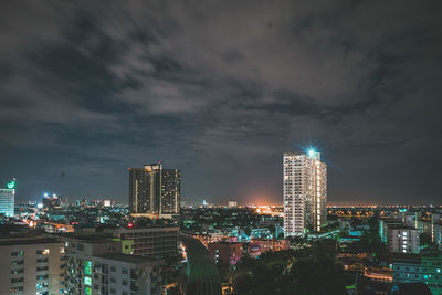 Illuminated buildings in city against sky at night