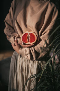 Close-up of woman holding red fruit