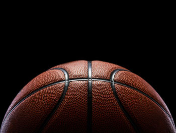 Close-up of basketball hoop against black background