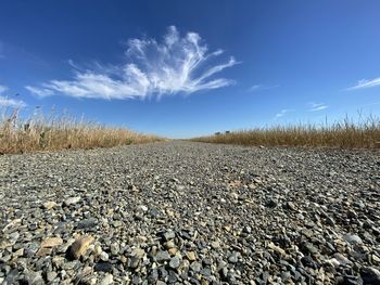 Surface level of stones on land against sky