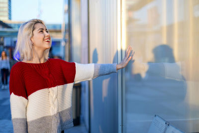 Young woman standing against window