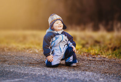 Cute boy kneeling on road