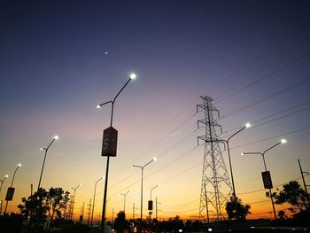 Low angle view of street lights against sky at night