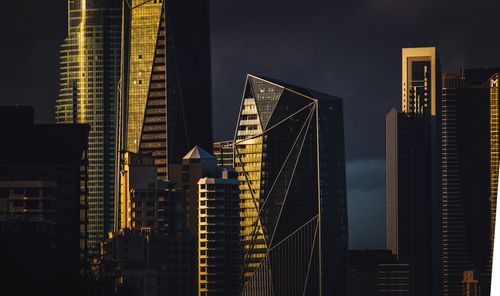 Low angle view of skyscrapers against sky at night