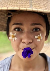 Close-up portrait of woman holding red flower